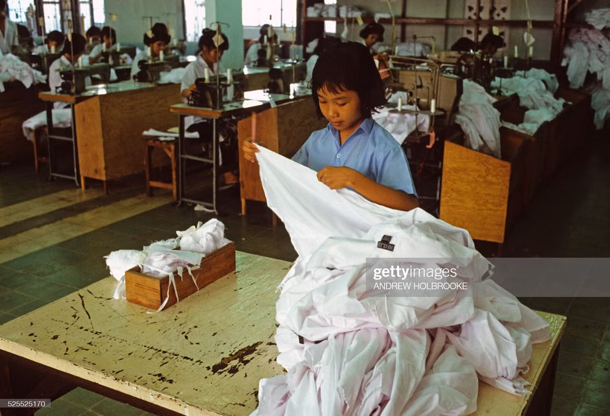 Thợ may nhỏ tuổi làm việc trong một xí nghiệp may mặc xuất khẩu.