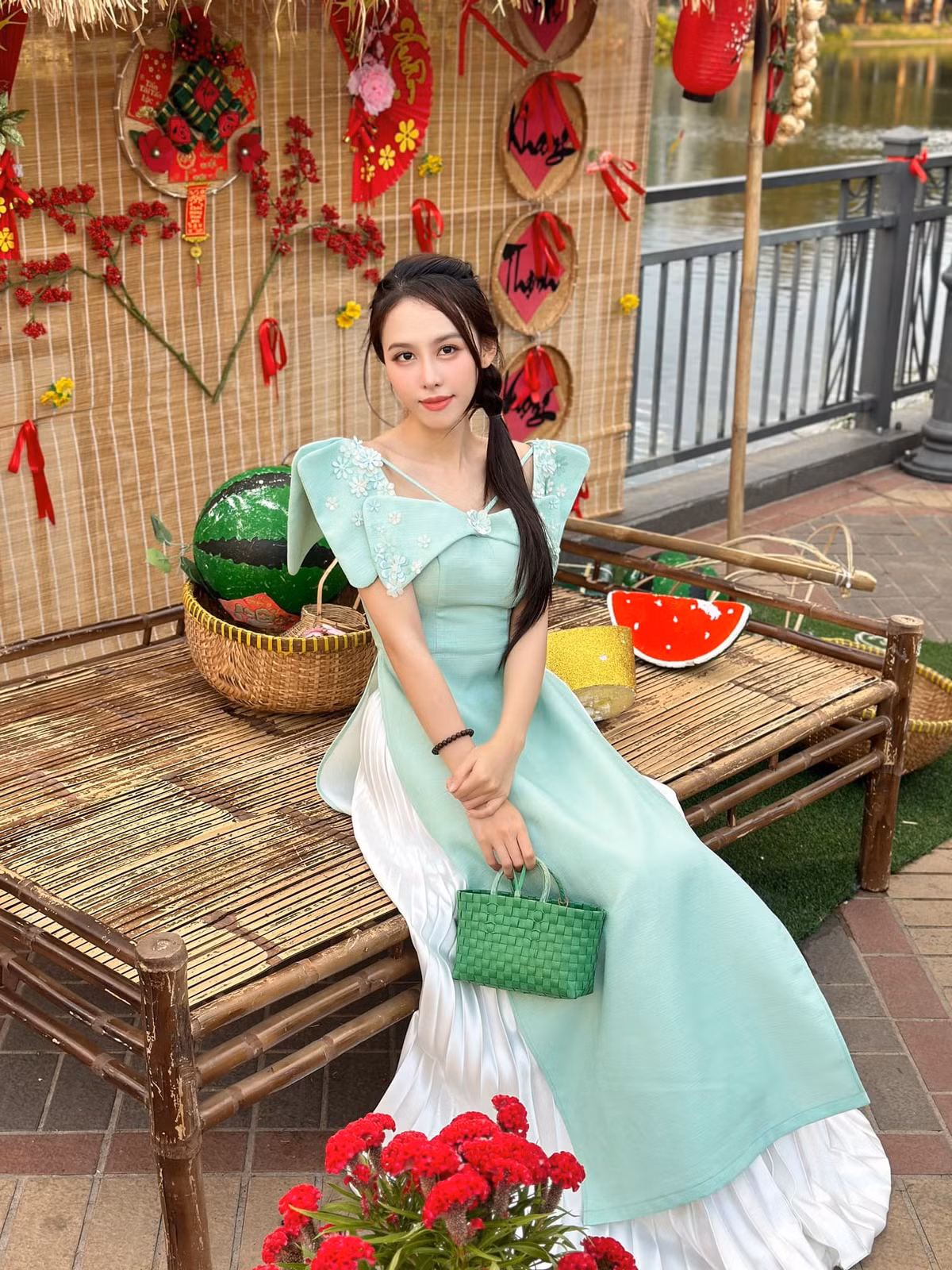 Á hậu Ngọc Hằng diện áo dài cách tân tông màu xanh pastel, phối cùng túi cói màu xanh độc đáo.