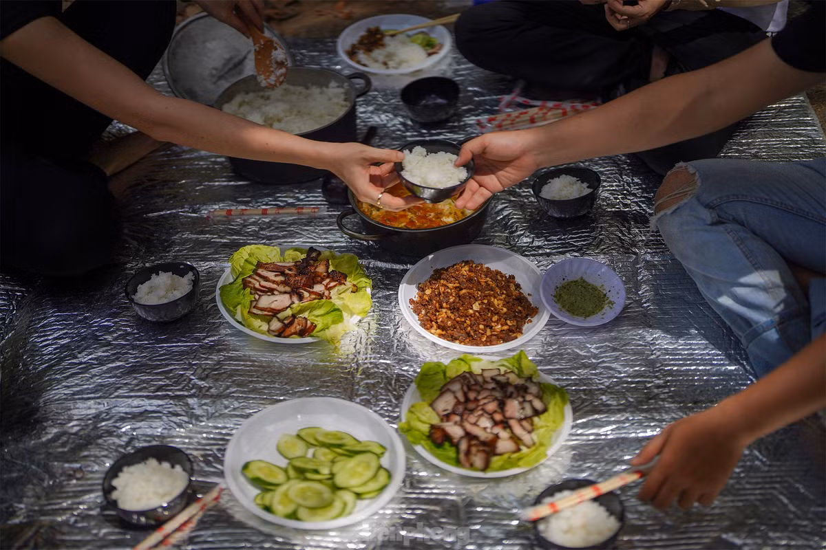 Trong khi du khách đi bộ thì đội hỗ trợ đã chuẩn bị cơm trưa. Nhóm khách trong ảnh được phục vụ món thịt lợn xông khói nướng hạt dỗi khá độc đáo của địa phương. Dòng nước suối nơi cấm trại mát lạnh đến nỗi có thể ngâm cả chai nước ngọt, đợi tầm 15 phút là có thể thưởng thức.