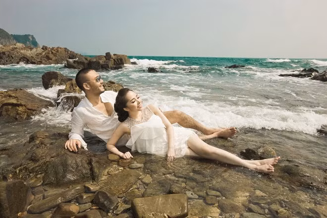 Khi đến với biển, cặp đôi chọn trang phục đồng gam trắng, phong cách hiện đại với kiểu dáng ngắn, phù hợp với không gian bờ biển thơ mộng.