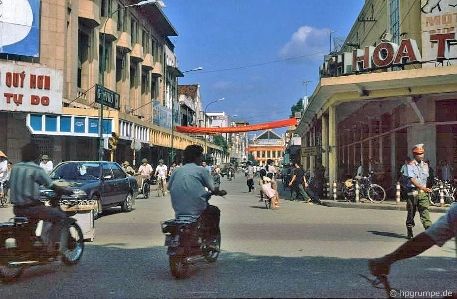 Các nam giới đi xe máy Honda Cub chạy qua ngã tư Tràng Tiền - Đinh Tiên Hoàng, Hà Nội năm 1991. Ảnh: Hans-Peter Grumpe / Hpgrumpe.de.