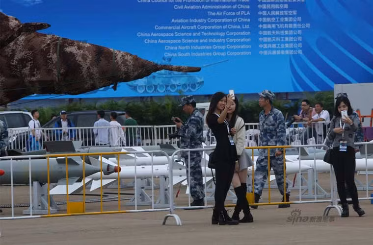 Các khách tham quan đang chụp hình tự sướng (Selfie) với các máy bay chiến đấu hầm hố.