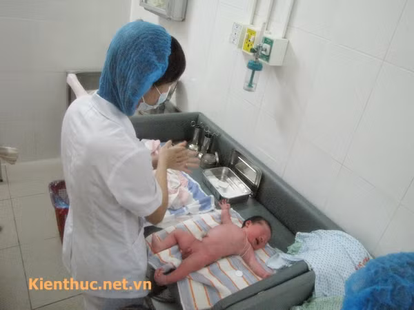 sau đó hộ sinh sẽ rửa sạch và sát trùng tay để làm rốn cho bé.