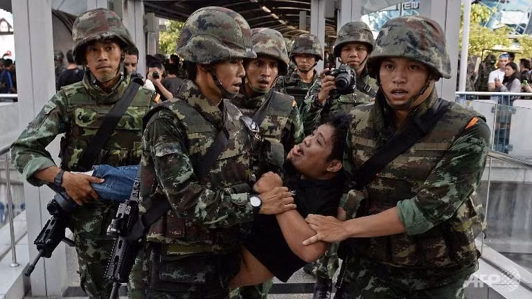 Các binh sĩ Thái Lan đang ngăn cản một người biểu tình phản đối cuộc đảo chính.