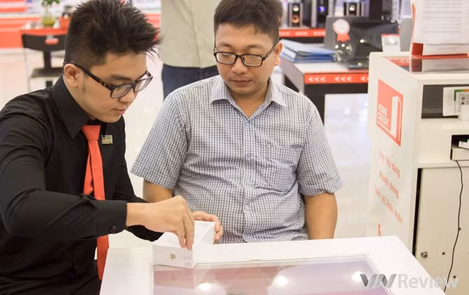 Sau đó nhân viên FPT Shop tiến hành khui hộp máy trước sự chứng kiến của khách hàng.