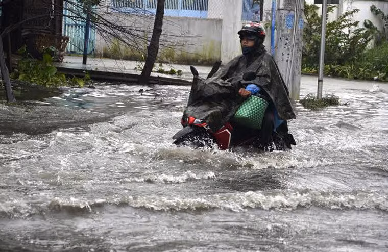 Người tham gia giao thông vô cùng khổ sở lội trong nước ngập hơn nửa bánh xe.