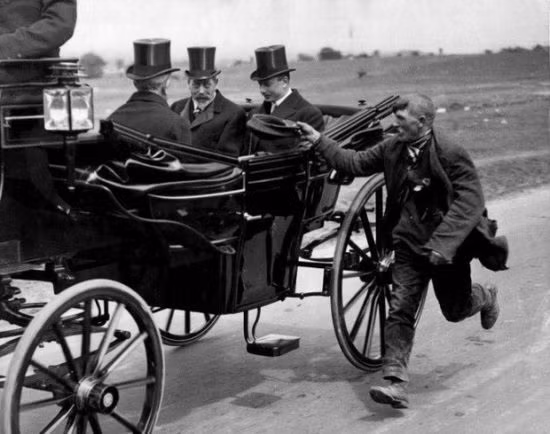 Một người ăn xin chạy theo vua George V của Vương quốc Anh năm 1920.