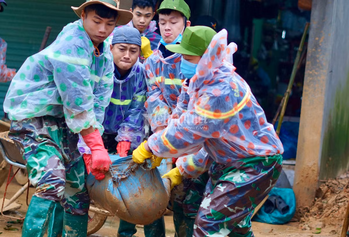 Cây gỗ, đất đá tràn xuống nhà dân được các chiến sĩ dọn dẹp.