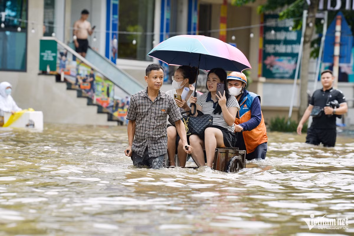 Người dân cho biết, cả khu này bị ngập từ hôm qua, tới sáng nay còn ngập sâu hơn. Một phụ nữ khóc lớn khi liên tiếp bị sóng nước đánh vào người.
