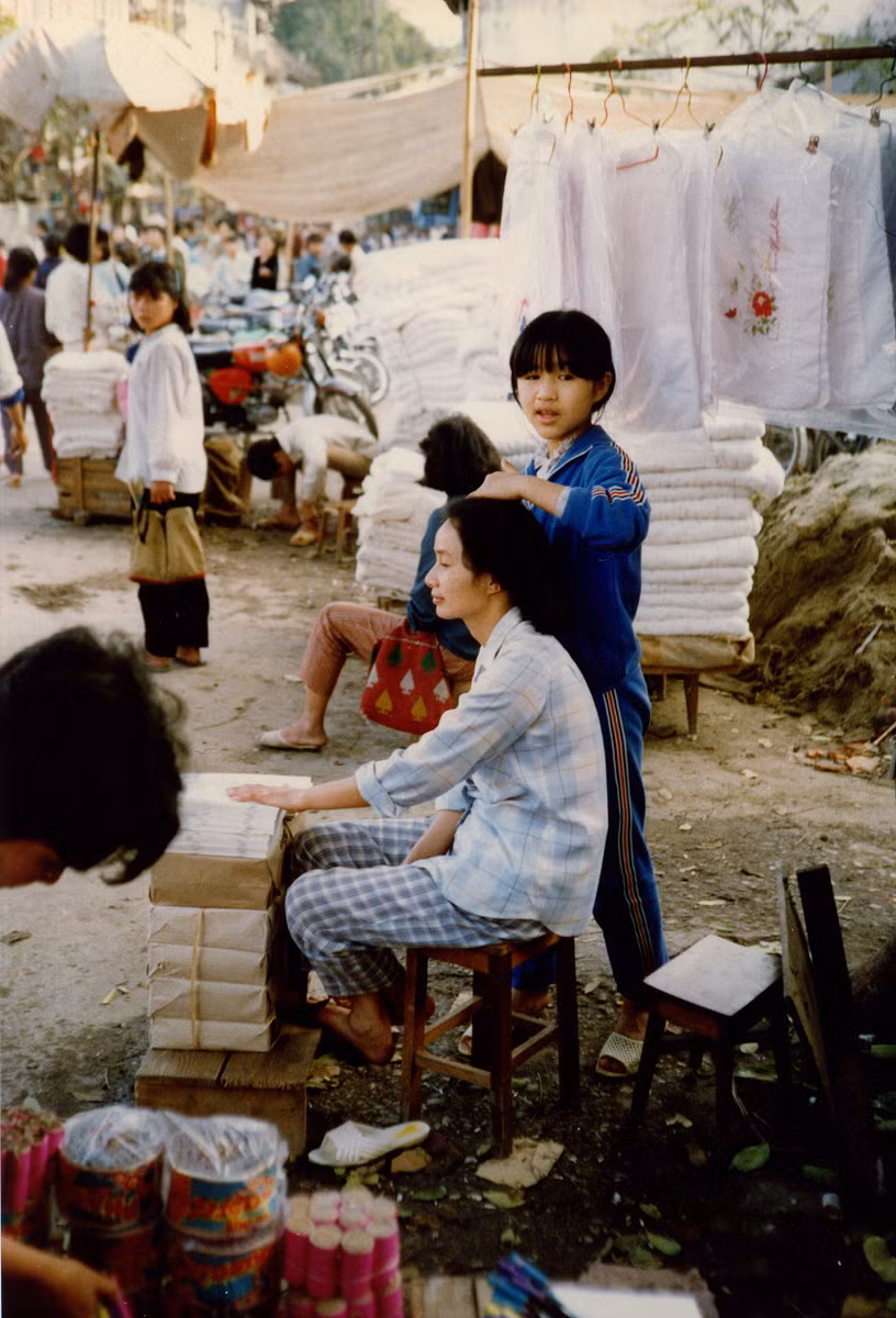 Một góc chợ vỉa hè Hà Nội. Những thứ màu hồng ở góc dưới bên trái là pháo Tết.