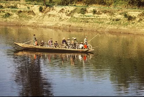 Một con đò chở hành khách cùng những chiếc xe đạp qua sông.