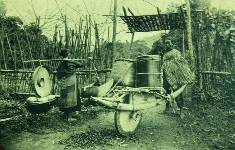 Nam giới đẩy xe cút kít và phụ nữ gánh quang gánh ở vùng nông thôn Việt Nam đầu thế kỷ 20.