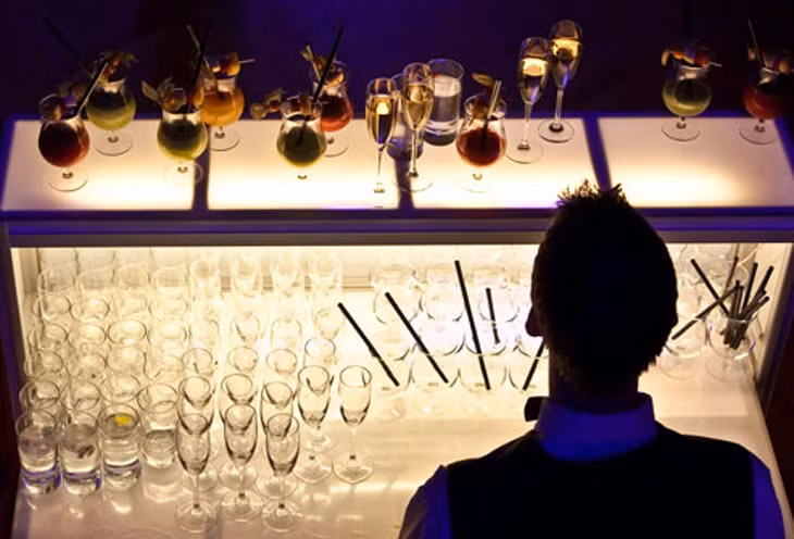 Nhân viên pha rượu. Nhiều quán bar mở đến tận hai giờ đêm khiến đội ngũ nhân viên ở đây bắt buộc phải đáp ứng yêu cầu của cửa hàng để phục vụ khách.