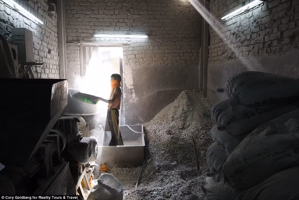 Một công nhân đang nung chảy nhựa tại một nhà máy tái chế. Người đàn ông này chỉ dùng một chiếc khăn để che mặt.