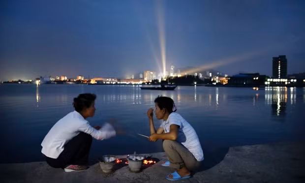 Những người phụ nữ nói chuyện bên cạnh các lò nướng hải sản tại một âu tàu ở Wonsan.