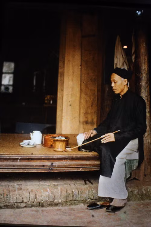 Cụ già sửa soạn thuốc lào.