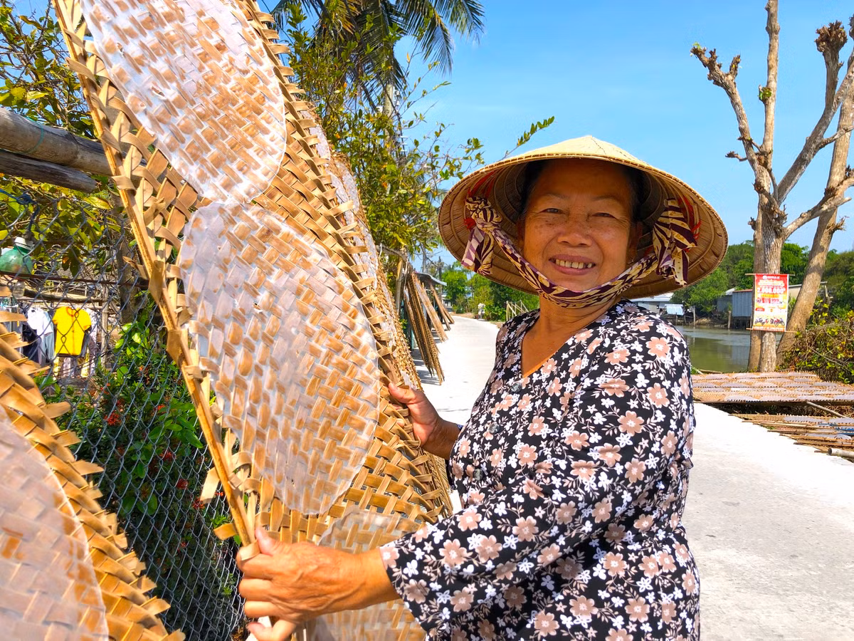 Bà Huỳnh Thị Giáo (67 tuổi, chủ lò bánh tráng ở phường Thuận Hưng) cho biết, từ tháng 11 Âm lịch làng nghề bắt đầu “vào mùa". "Để tạo ra chiếc bánh tráng phục vụ các bữa ăn ngày Tết của người dân miền Tây, từ sáng hôm trước tôi bắt đầu ngâm gạo, chiều đến thì xay bột, rồi để lắng qua đêm. Khoảng 1h sáng vợ chồng tôi đã thức dậy để nhóm lửa, chuẩn bị vỉ, khuấy bột,...tới 3h các thợ tráng bánh đến làm. Cứ đến đợt Tết là mỗi ngày 2 vợ chồng tôi chỉ ngủ được vài giờ. Cực nhưng vui", bà Giáo chia sẻ - Ảnh: Kim Hà.