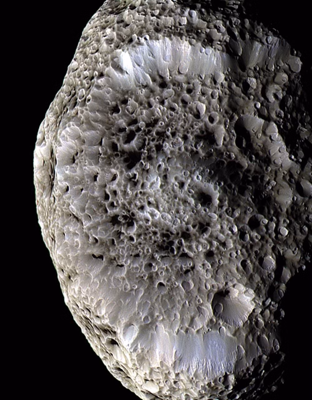  13. Hyperion (Sao Thổ). Mặt trăng này có hình dạng không đều và bề mặt xốp như bọt biển, phản chiếu ánh sáng mạnh. Nó chuyển động hỗn loạn và không quay theo trục cố định. Ảnh: Pinterest.