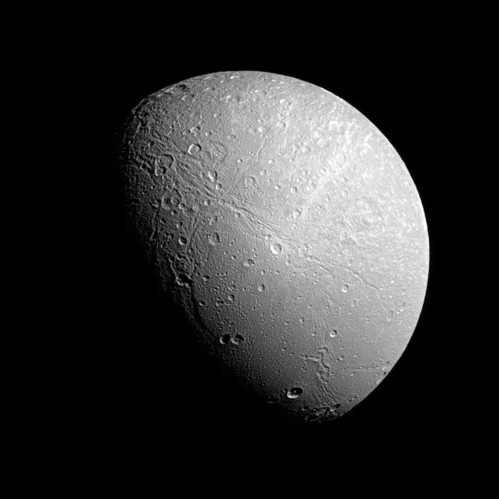  19. Dione (Sao Thổ). Dione có các vết sáng dài trên bề mặt, là các khe nứt băng được ánh sáng phản chiếu mạnh. Nó có thể có đại dương ngầm như Enceladus. Ảnh: Pinterest.