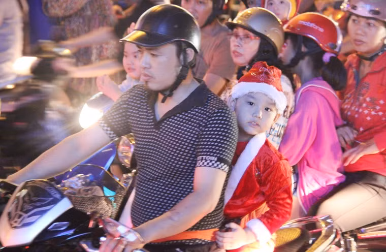 Một em bé thích thú hóa thân thành "Ông già Noel" dạo phố.