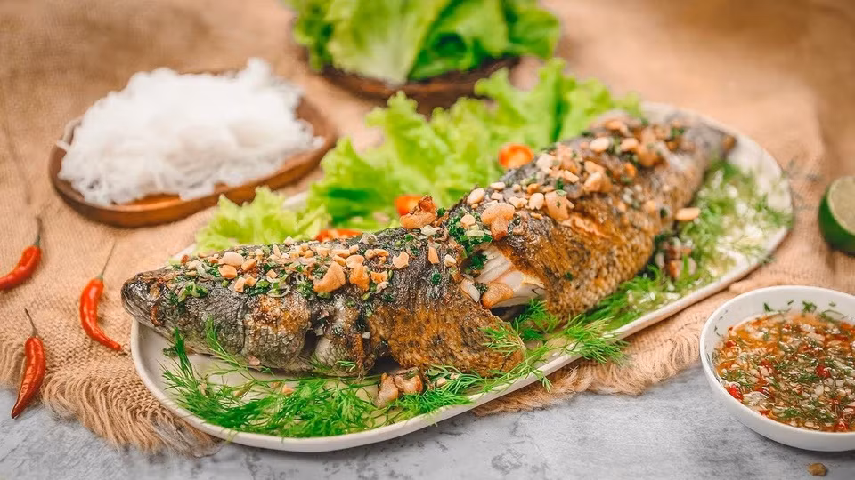 br/> Cá lóc nướng trui: Nhắc đến đặc sản Cà Mau, không thể bỏ qua cá lóc nướng trui - món ngon nổi tiếng của vùng sông nước miền Tây. Cá lóc sau khi bắt về được đắp đất sét xung quanh rồi nướng trong bếp rơm, đến khi thấy mùi thơm thì cho ra đĩa. Món ăn này ngon nhất khi được nướng chín tới, thịt cá trắng phau bao ngoài bởi lớp vảy cháy xém, cuốn ăn cùng bánh tráng, rau sống gồm bắp chuối, rau đắng, xà lách, lá cóc non… Chấm một cuốn vào chén nước chấm pha sẵn, thực khách sẽ cảm nhận được vị ngon đặc biệt, khó thể tìm thấy ở bất kỳ món nào khác. Ảnh: sieungon.com