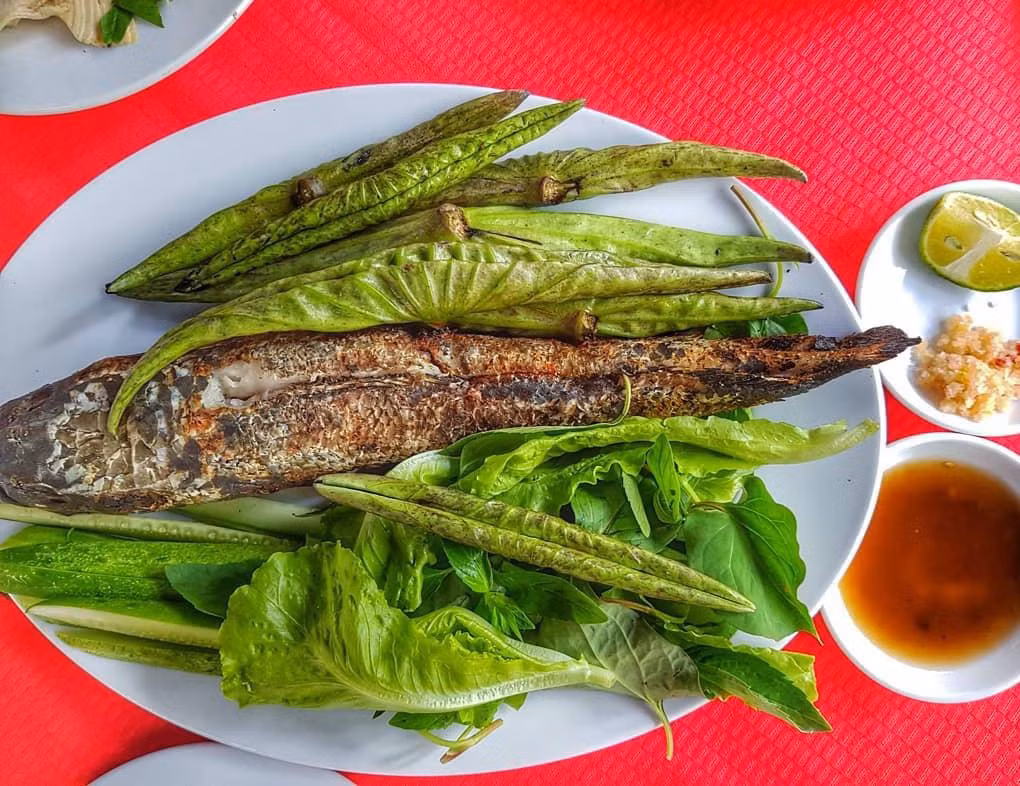 Ở miền Tây, cá lóc nướng có thể cuốn lá sen non lạ miệng, thay vì cuốn bánh tráng như thường thấy. Lá sen non tươi xanh, có mép lá còn cuốn chặt, dài chừng gang tay, được cắt đến sát cuống. Khi ăn, thực khách chỉ cần gỡ nhẹ từng miếng thịt cá trắng nõn, cho vào lá sen non mở ra rộng bản, cuốn lại, chấm mắm me là có thể thưởng thức ngay. Ảnh: Hainguyen1886.