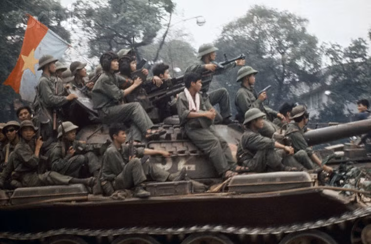Bộ binh ngồi trên chiếc xe tăng chiến đấu chủ lực T-54 của quân giải phóng lăn bánh trên đường phố Sài Gòn. Xe tăng T-54 là một trong những “mũi tên thép” chủ lực của quân giải phóng đã đập tan mọi tuyến phòng ngự của Quân đội Sài Gòn. 