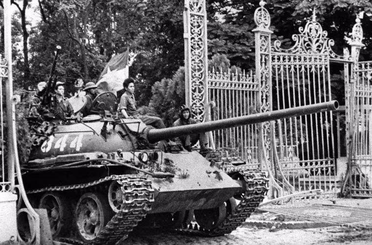 10h45 phút ngày 30/4, xe tăng T-54 mang số hiệu 843 húc nghiêng cổng phụ Dinh Độc Lập và bị kẹt tại đó. Ngay sau đó chiếc xe Type 59 số hiệu 390 liền xông tới húc tung cánh cổng chính của Dinh Độc Lập. Trong ảnh là xe tăng T-54 khác tiến qua cánh cổng đã bị húc đổ. 