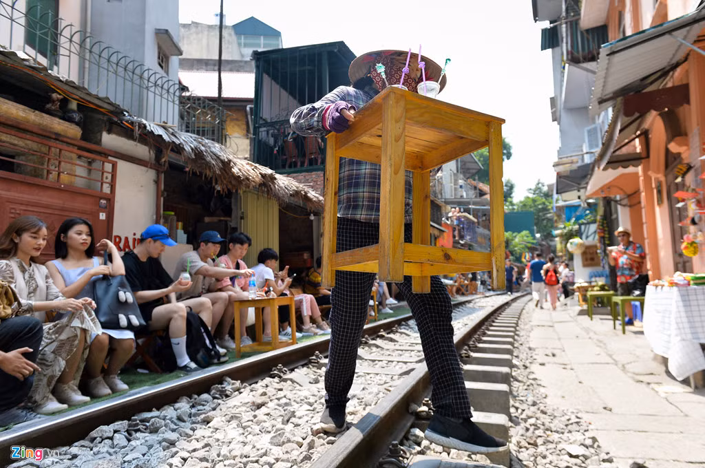Trước khi tàu chạy khoảng 5 phút, nhân viên quán sẽ đi nhắc nhở và bê bàn ngoài đường sắt vào trong nhà.
