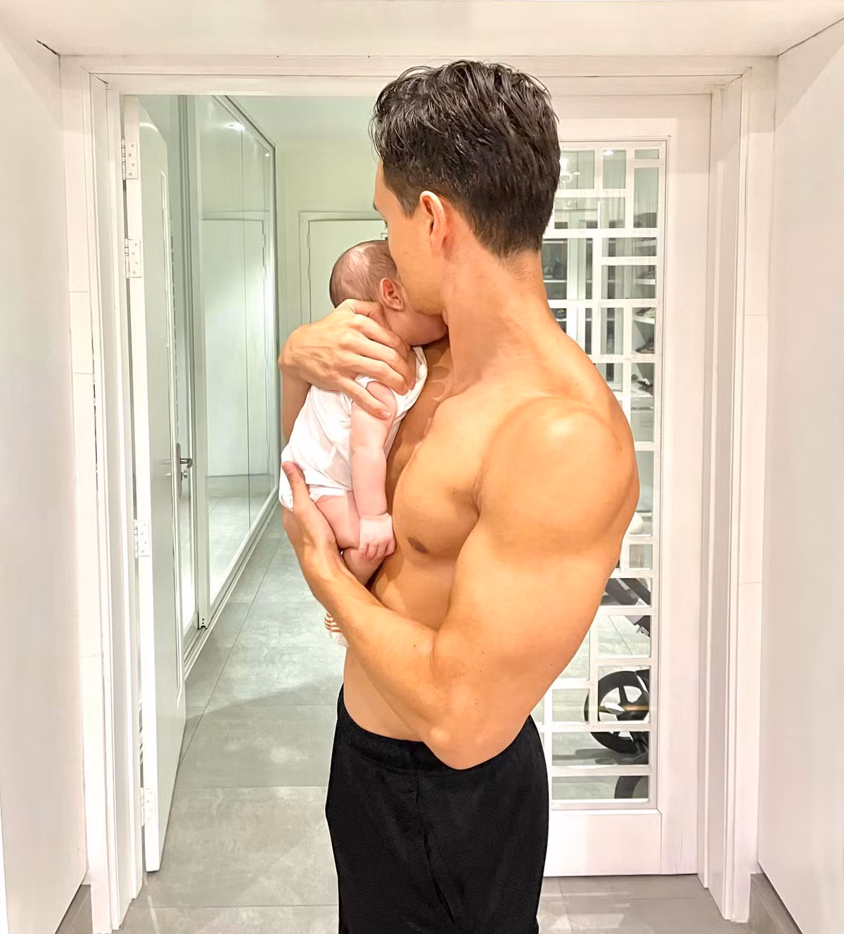 Kim Lý vừa bế con Leon vừa khoe cơ bắp.