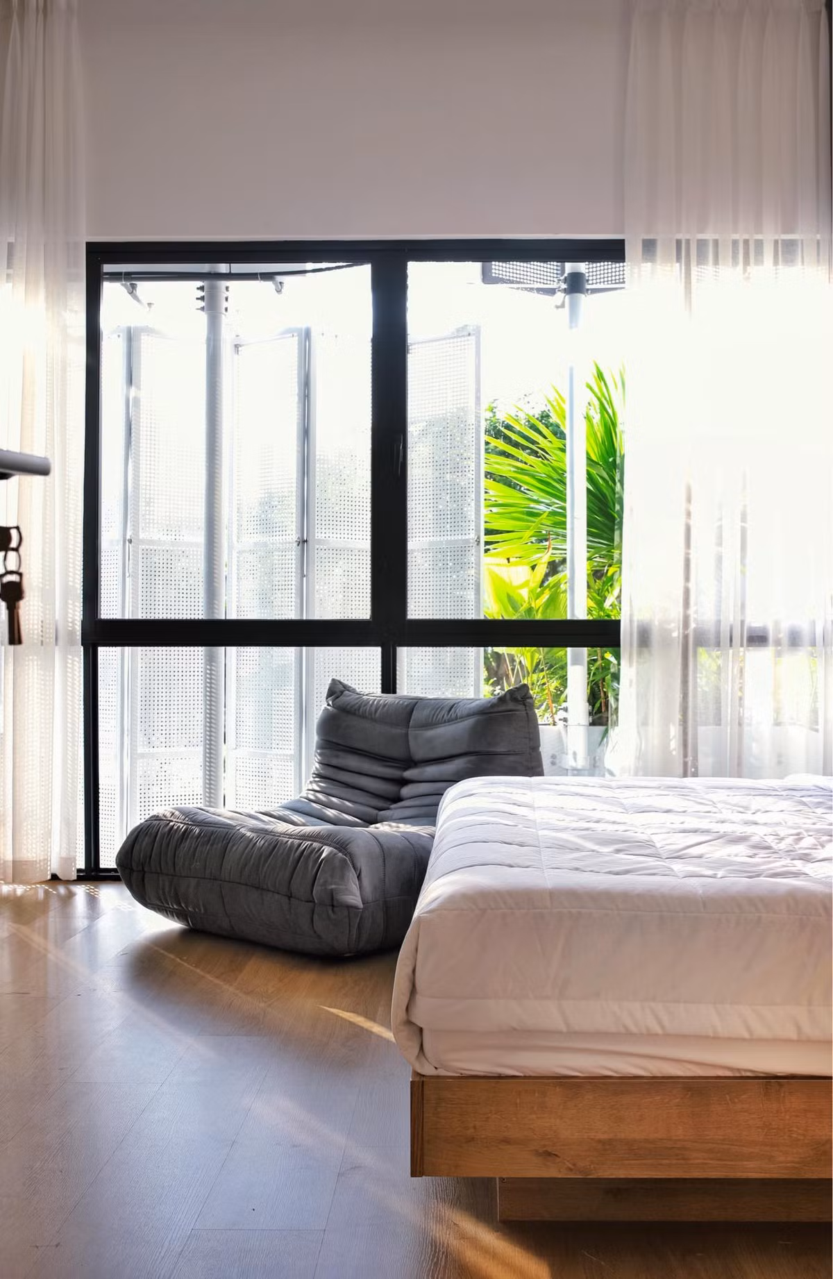 Riêng phòng ngủ ông bà, khoảng lùi được tận dụng để làm sàn thưa gỗ, thêm được không gian ngồi thư giãn nhưng vẫn làm tốt vai trò lưu thông không khí. 