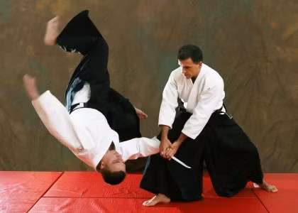 Aikido là một môn võ thuật hiện đại của Nhật Bản được Ueshiba Morihei (1883-1969) sáng tạo ra trên cơ sở các môn võ thuật cổ truyền của Nhật Bản như Nhu thuật (Jujitsu), Kiếm thuật (Kenjutsu), và Thương thuật (Sojutsu). Trong Aikido, cũng như tất cả các môn võ Nhật Bản khác, vừa có sự luyện tập thể chất, vừa có sự luyện tập về mặt tinh thần. Việc luyện tập thể chất trong Aikido rất phong phú, bao gồm cả luyện tập thể chất và trau dồi kinh nghiệm nói chung, cũng như các kĩ thuật đặc biệt. Bởi một phần quan trọng trong việc luyện tập Aikido luôn bao gồm đòn ném đối thủ, nên điều đầu tiên môn sinh cần học là làm thế nào để ngã hoặc lăn an toàn. Các kĩ thuật đánh đặc biệt bao gồm đánh và nắm; các kĩ thuật phòng thủ bao gồm ném và khóa. Sau khi học xong các kĩ thuật cơ bản, môn sinh bắt đầu phòng thủ tự do chống lại nhiều đối thủ, và trong nhiều trường hợp là các kĩ thuật chống vũ khí. Ảnh: Aikido-ab.