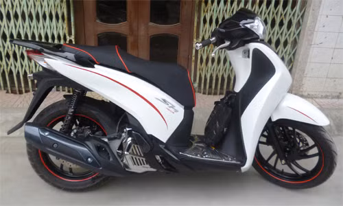Chiếc SH 2012 màu trắng nguyên bản được chủ nhân của nó độ kiểu dáng thể thao khi sơn lại vành xe, giảm xóc, tay nắm phía sau, phun carbon ở phần đầu xe hay yên xe với đường chỉ đỏ.