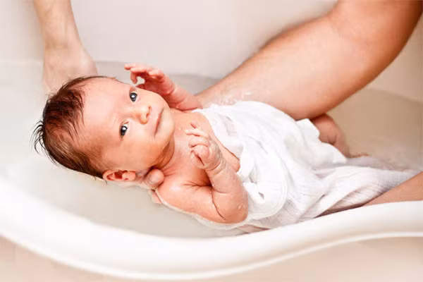 Chưa quen nhiệt độ cơ thể. Trẻ vừa mới lọt lòng mẹ đang tìm cách duy trì nhiệt độ cơ thể mình. Tách bé ra khỏi phòng tắm, có thể làm cho bé chới với với nhiệt độ mới. Vì điều này, có một số trường hợp, em bé sơ sinh cần đặt dưới đèn nhiệt để lấy lại nhiệt độ sau khi tắm.