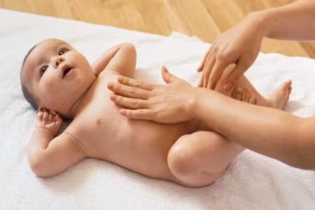 Cha mẹ nên đặt bé nằm, hằng ngày làm các động tác massage nhẹ thành bụng của bé.