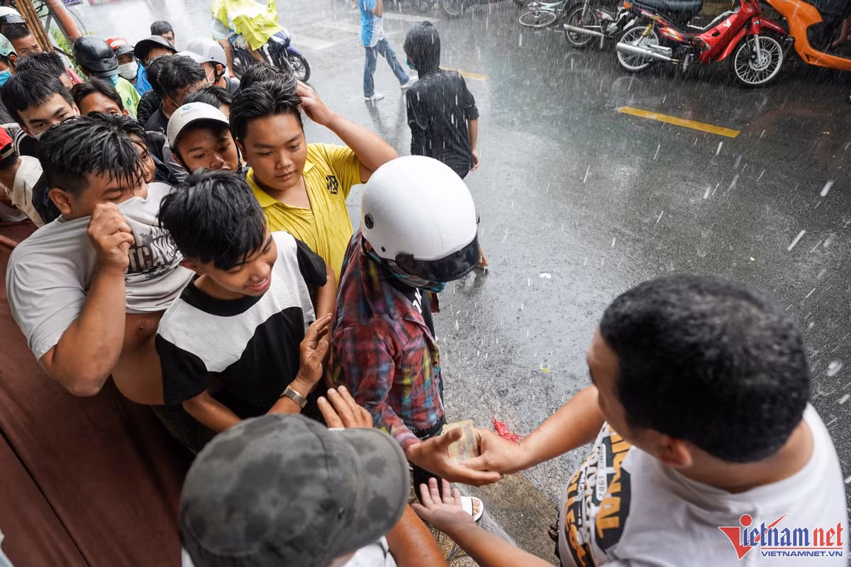 Dù bên ngoài trời mưa to, vẫn có nhiều người đổ về để nhận tiền cúng của chủ nhà.