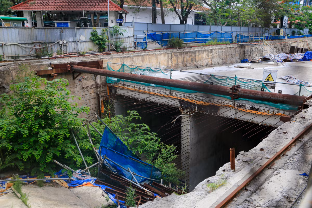 Bên trong công trường một số giàn giáo sập xuống hố, vật liệu chất thành đống, có dại mọc um tùm không có ai dọn dẹp.