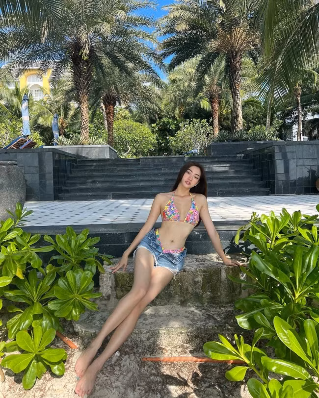 Hoa hậu Lương Thùy Linh diện áo tắm nhưng kết hợp thêm với hot pants và mặc theo kiểu không đóng cúc.