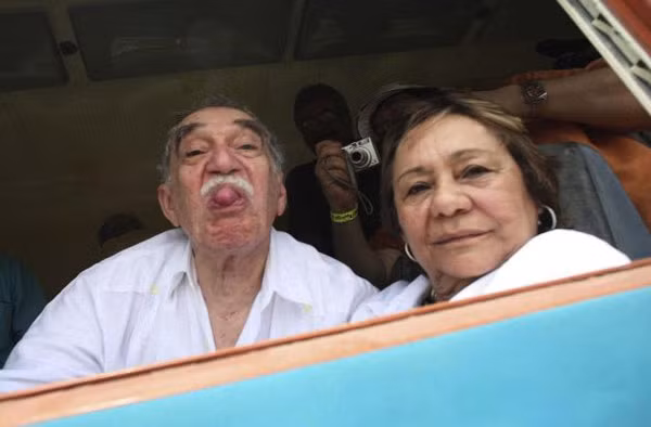 Gabriel Garcia Marquez lè lưỡi về phía các phóng viên ảnh khi ông ngồi trên tàu cùng vợ về quê Aracataca, Colombia.