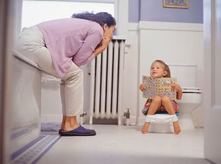 Tập cho bé làm quen với nhà vệ sinh. Bạn hãy chơi trong nhà vệ sinh cùng với bé để giúp bé thấy rằng đó không phải là một nơi tồi tệ. Cho bé thử ngồi trên bồn cầu trong vài phút dù vẫn đang mặc quần. Bạn có thể dùng thêm một chiếc ghế nhỏ để bé gác chân.