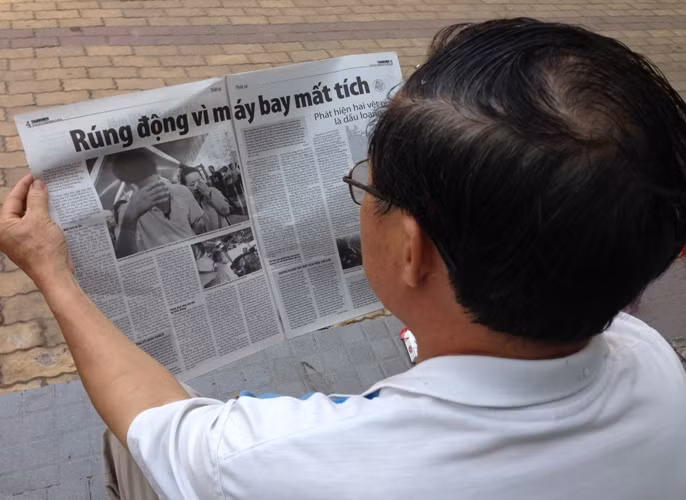 Một người dân đọc thông tin trên báo giấy.
