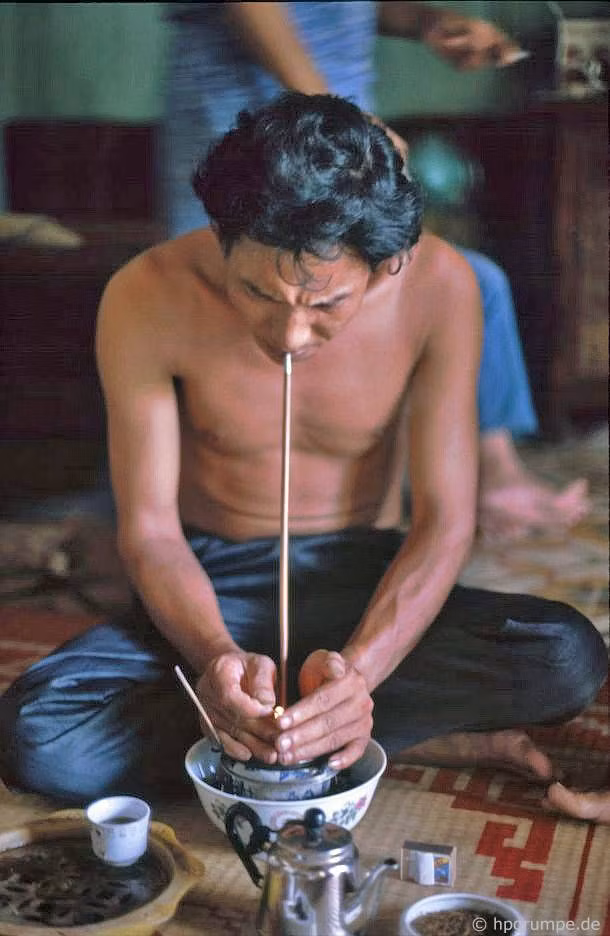 Người thanh niên trong gia đình hút thuốc bằng điếu bát.