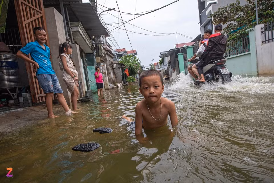 Con đường chính trong làng trở thành bãi tắm cho người dân xóm Bến Vôi trong những ngày nước lũ dâng cao.