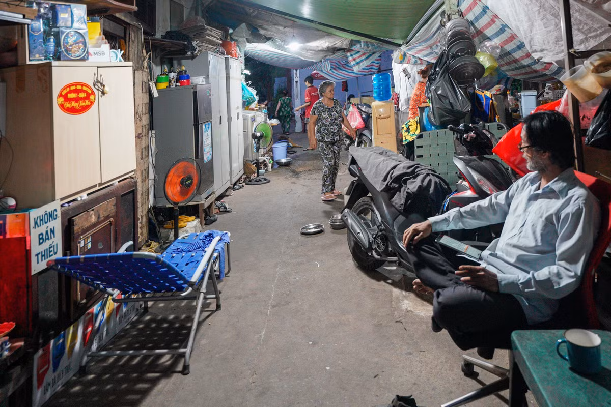 Gia đình của em trai ông Lâm (bên phải) cũng tận dụng lối đi của con hẻm để làm nơi ở tạm. Neo người, nhiều thiếu thốn, song cuộc sống tại hẻm cù lao Nguyễn Kiệu không hề nhàm chán. Phần lớn cư dân đã sống tại đây cả cuộc đời, coi hàng xóm như người thân trong gia đình. Chiều tối, mọi người thường tụ tập ca hát, tám chuyện, đôi khi cũng rủ nhau qua nhà dùng bữa cơm chung.