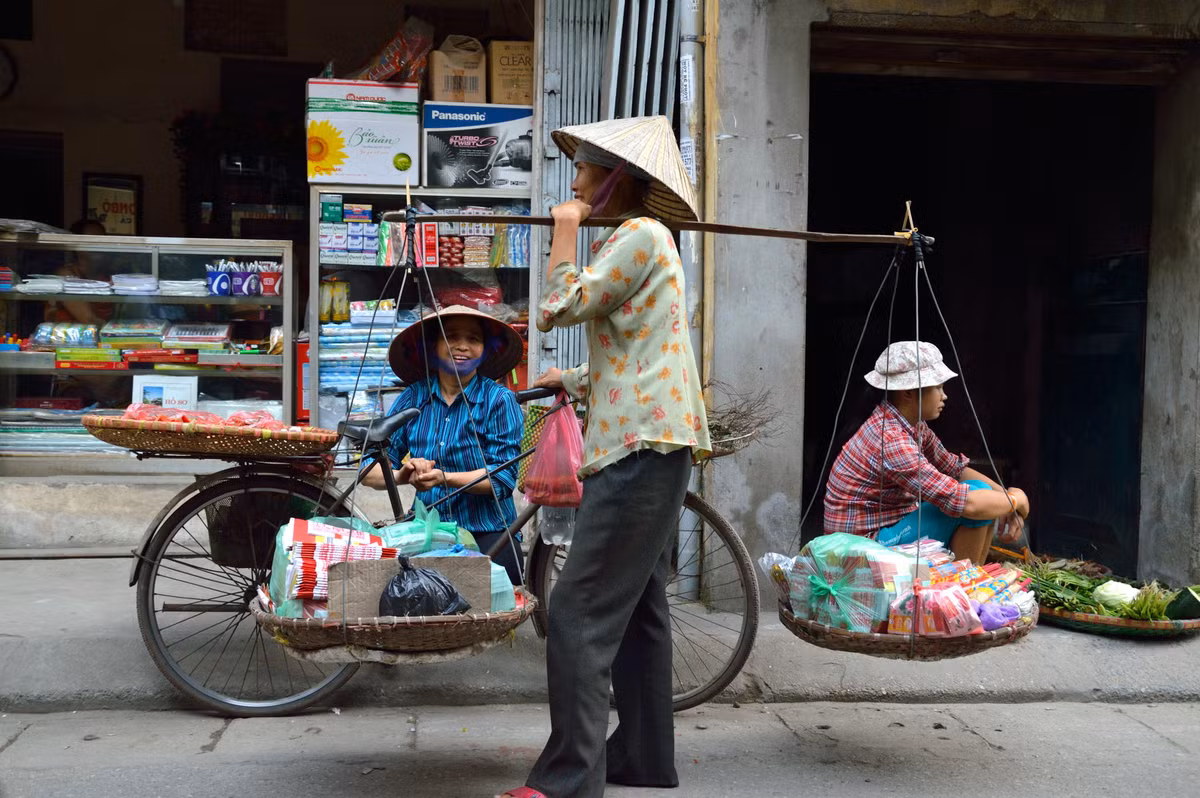 Những người bán hàng rong với quang gánh trên vai.
