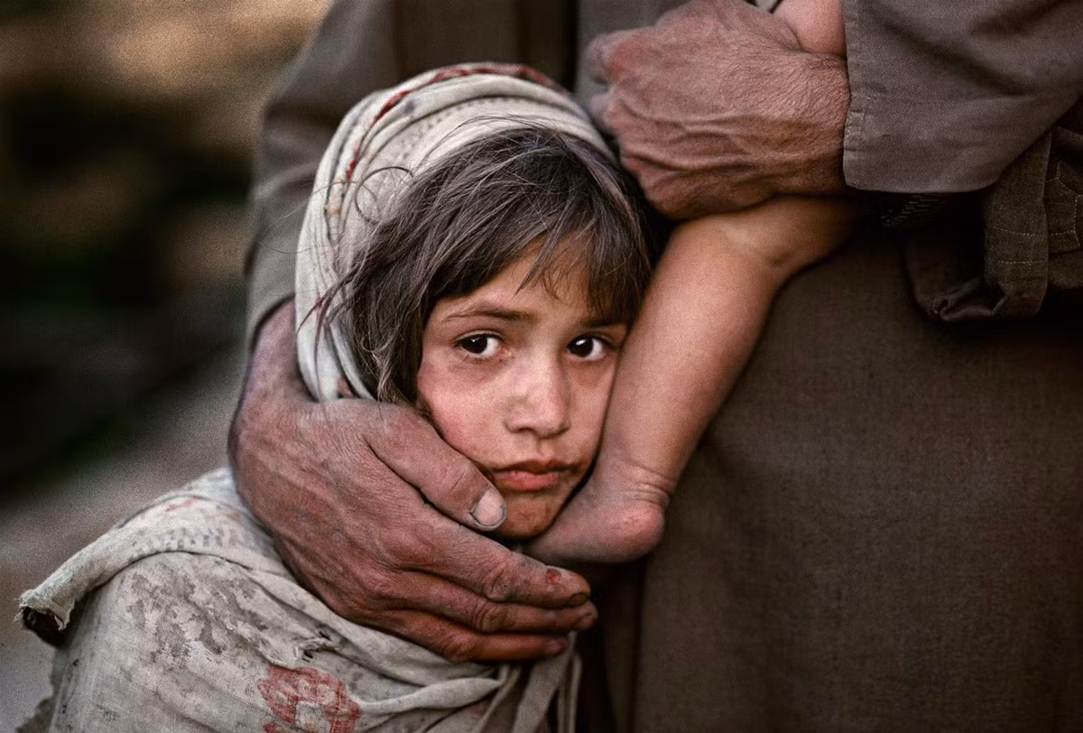 Bé gái cùng cha và em di tản chiến tranh gần Faisabad, Afghanistan năm 1990.