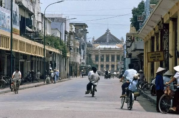 Phố Tràng Tiền vẹn nguyên vẻ đẹp trường tồn cùng thời gian. Phương tiện đi lại chủ yếu của người dân Hà Nội thời bấy giờ là xe đạp, xích lô, xe phân khối nhỏ.