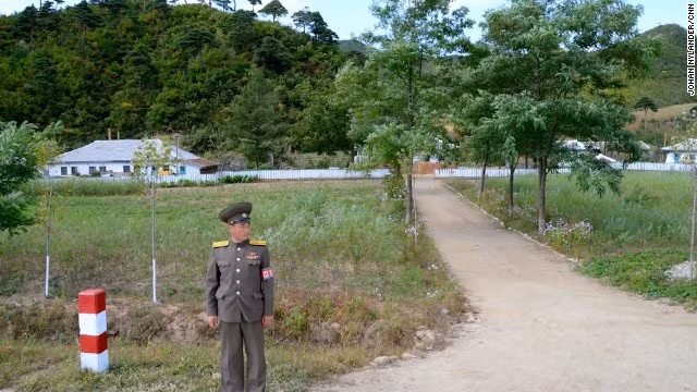 Một nhân viên an ninh Triều Tiên được giao nhiệm vụ giám sát các tay đua xe đạp gần một ngôi làng nhỏ.