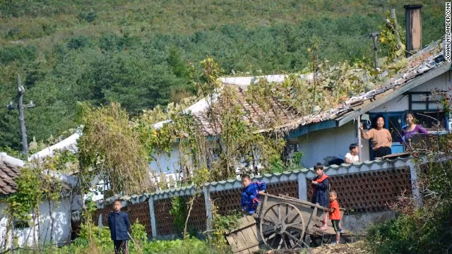 Trẻ em và phụ nữ Triều Tiên chờ xem các tay đua xe đạp đi qua.
