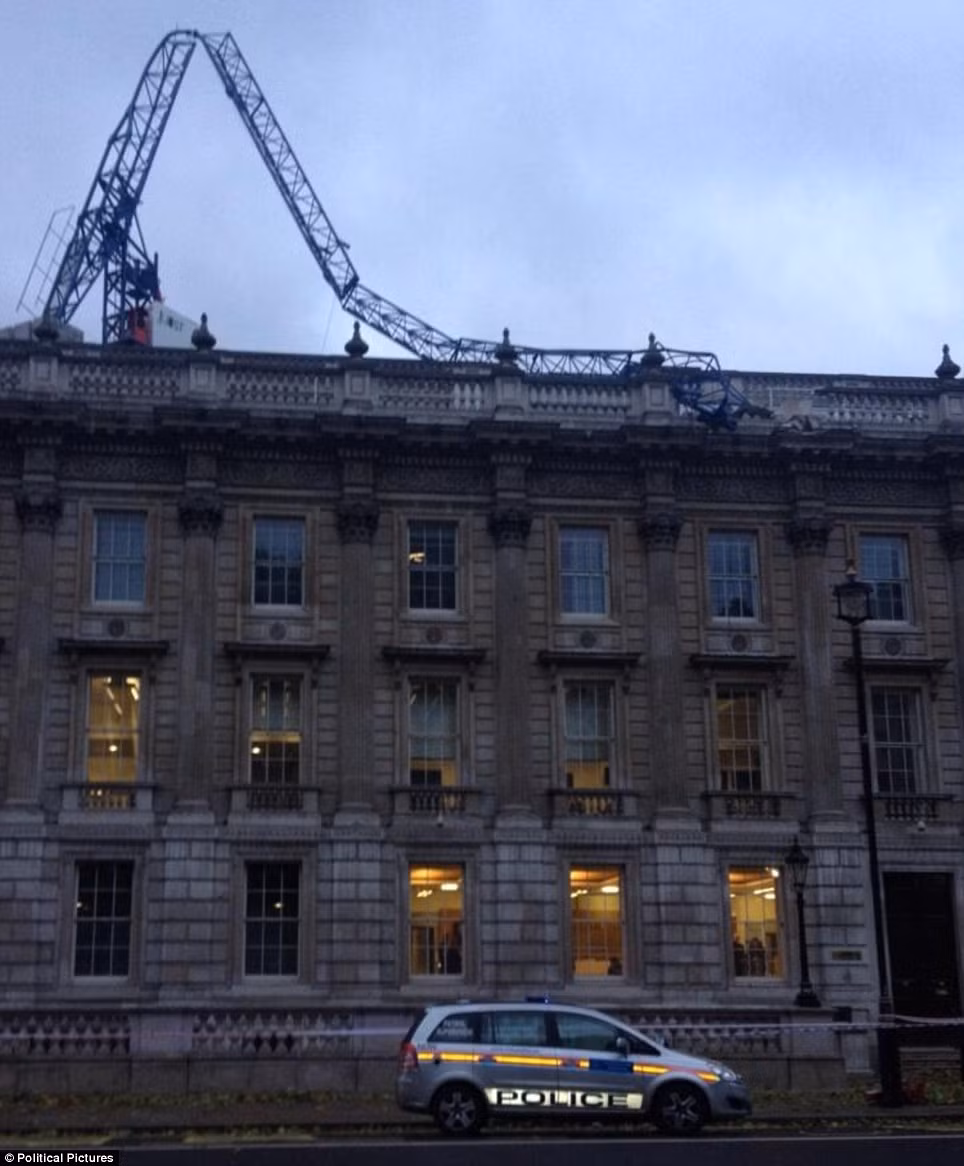 ... các tòa nhà bị bão tàn phá, mất điện trên diện rộng. Trong ảnh, một cần trục ở Downing Street đổ sập lên mái của Văn phòng Nội các Anh.
